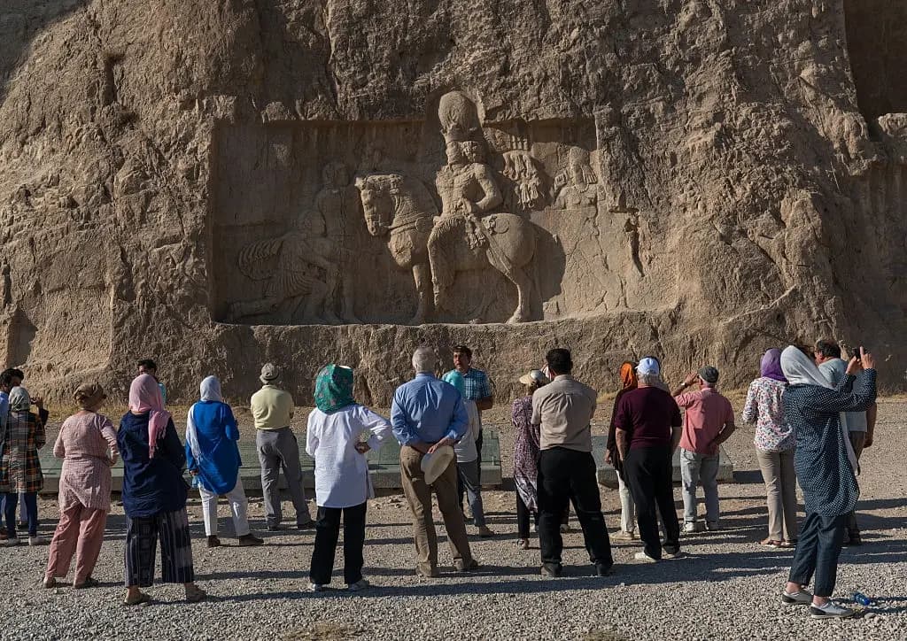 A tour guide explaining something to a group of tourists.